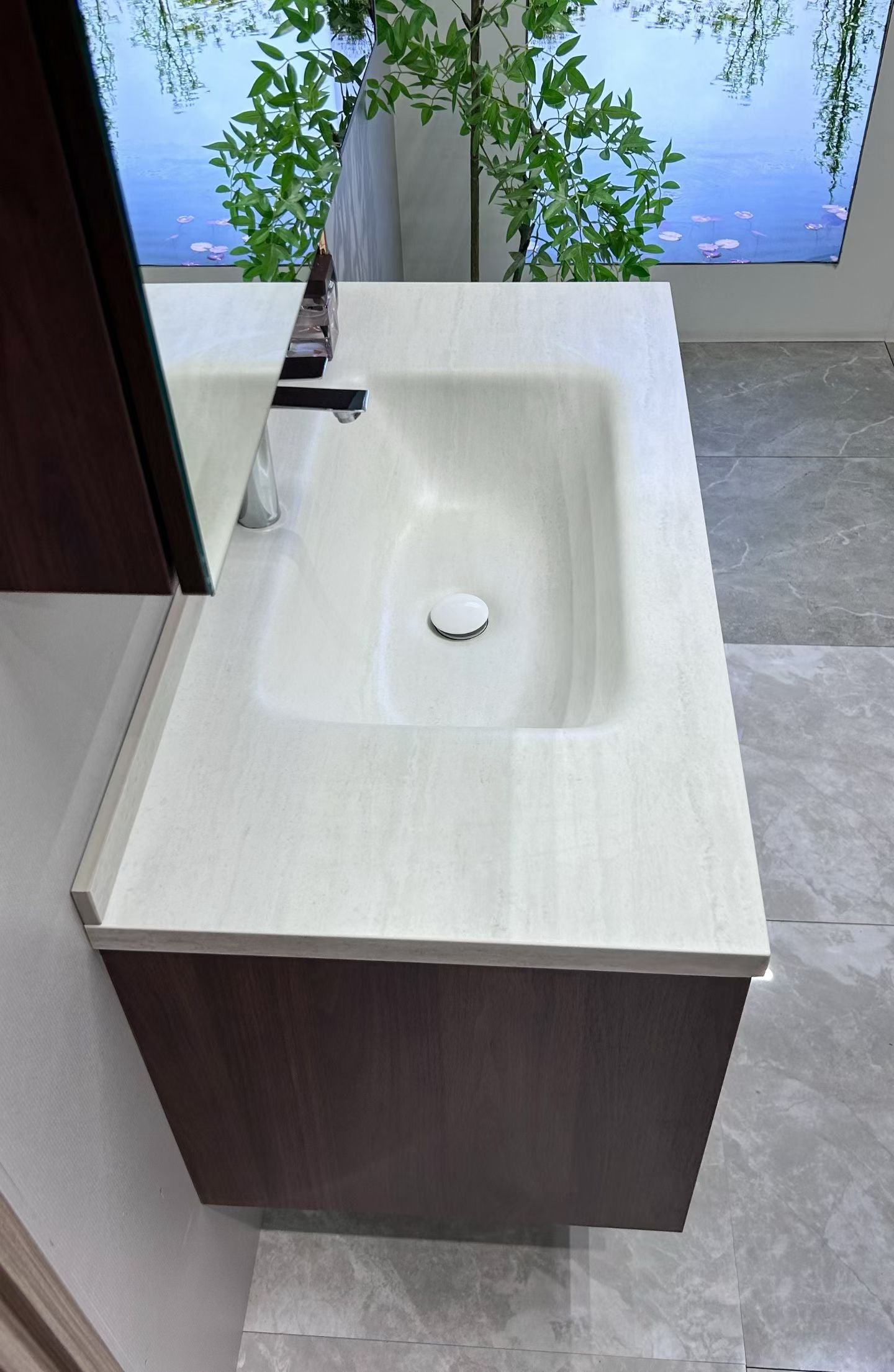 A luxurious solid wood bathroom cabinet with a walnut finish, a washbasin, and an integrated stone slab – an eco-friendly bathroom cabinet.
